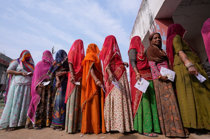Women wait cast their votes in a state election in Rajasthan in 2023. AP