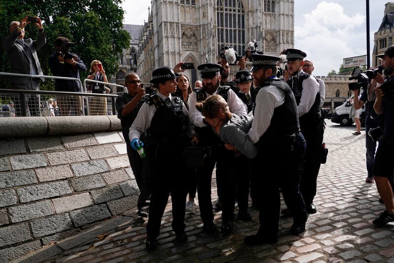 Police officers detain a protester before the result of the Conservative Party leadership contest, near the Queen Elizabeth II Centre. AP 