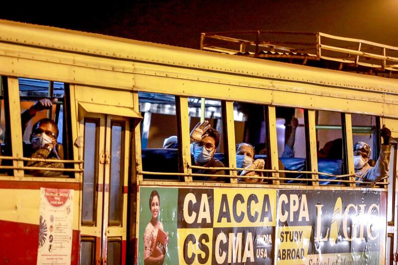 Indian citizens arriving with a special flight from Abu Dhabi of the United Arab Emirates sit on a bus before being shifted to a quarantine centre, as part of a massive repatriation effort due to the COVID-19 coronavirus pandemic, at the Cochin International Airport in Kochi early on May 8, 2020. - The first wave of a massive exercise to repatriate hundreds of thousands of Indians stuck abroad began on May 7, with two flights landing in India from the United Arab Emirates. (Photo by Arunchandra BOSE / AFP)