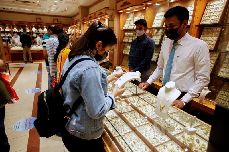 A customer examines a gold item at the Devji shop. Reuters