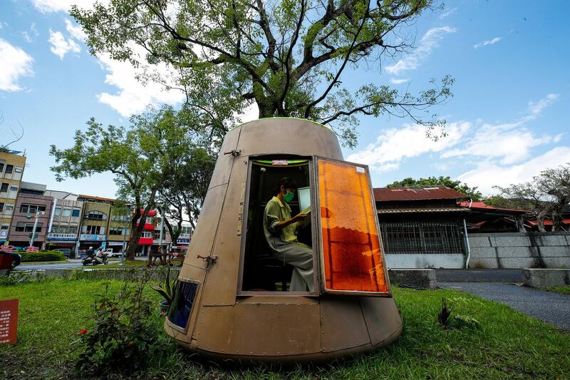A woman reads a book inside the space capsule replica outside a bookstore in Yilan, eastern Taiwan.  EPA