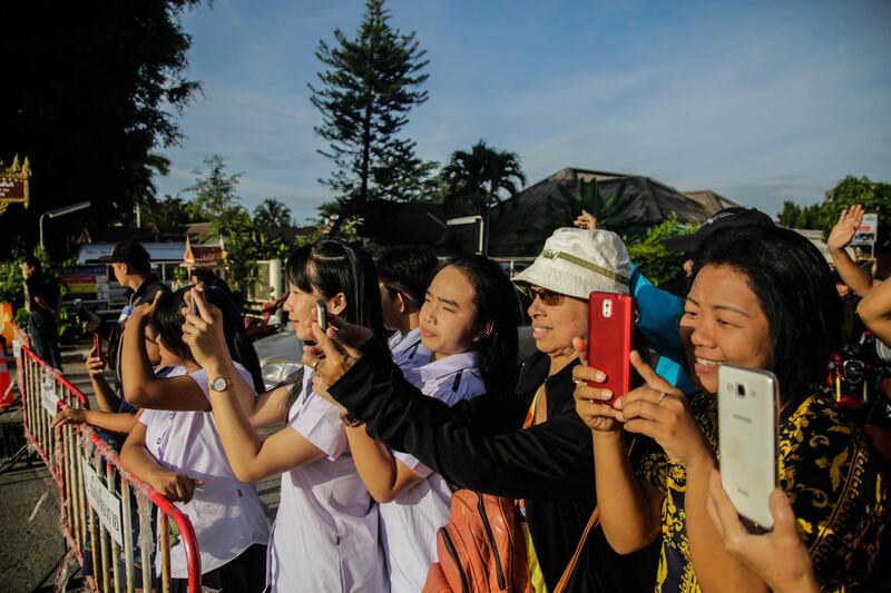 Onlookers watch and cheer as a helicopter flies towards an airstrip near Tham Luang Nang Non cave to transport the fifth boy rescued from the cave to hospital. Getty Images