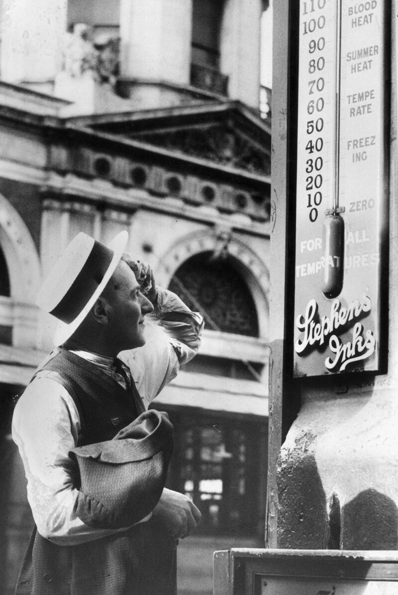 A passer by mops his brow as he reads a thermometer in Smithfield Market, London, in 1938.