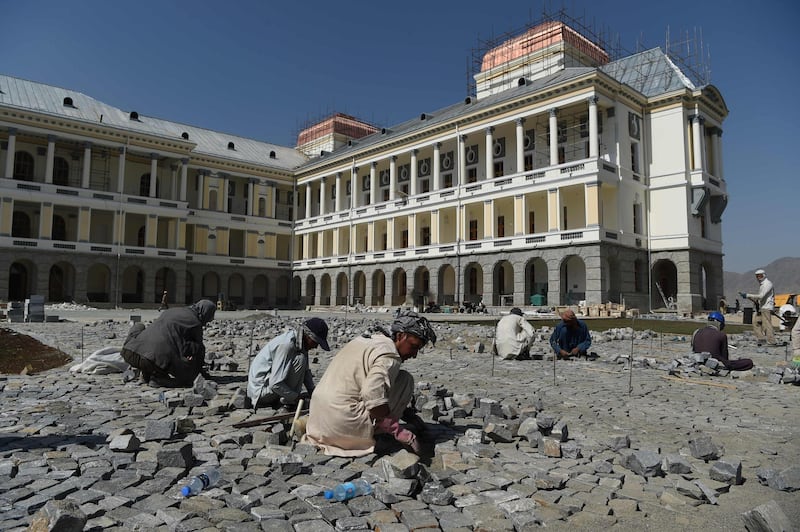 In this photo taken on August 8, 2019 Afghan labourers work on the exterior renovation of Darulaman Palace in Kabul. Work to completely renovate the once-ruined Darulaman Palace must be completed by August 19, the date marking 100 years of Afghan independence from Britain, when President Ashraf Ghani will inaugurate the newly finished structure that has came to reflect the country's turmoils during decades of war. - To go with 'AFGHANISTAN-HISTORY-CENTENARY,FOCUS' by Thomas WATKINS
 / AFP / WAKIL KOHSAR / To go with 'AFGHANISTAN-HISTORY-CENTENARY,FOCUS' by Thomas WATKINS
