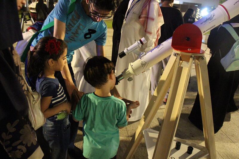 Children use a telescope to gaze at the stars at the AstroGeeks event. Photo: Ghaida Aloumi