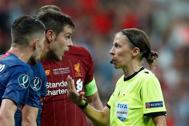 Referee Stephanie Frappart shows a yellow card to Chelsea's Cesar Azpilicueta, 2nd left, during the UEFA Super Cup soccer match between Liverpool and Chelsea, in Besiktas Park, in Istanbul, Wednesday, Aug. 14, 2019. (AP Photo/Thanassis Stavrakis)