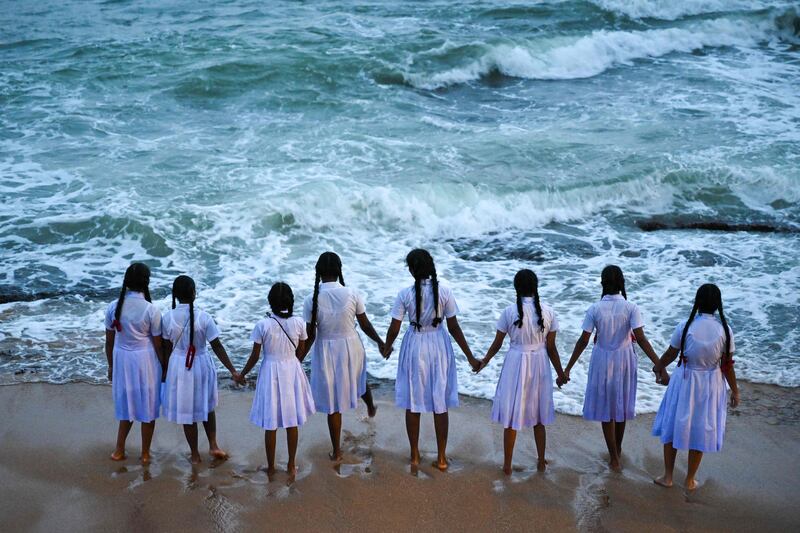 Schoolgirls hold hands while looking out at the Indian Ocean at Galle Face beach in Colombo, Sri  Lanka. AFP