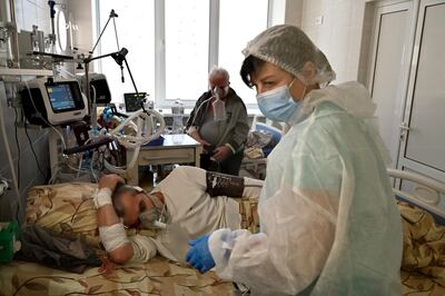 Medical personnel provides medical assistance to a Covid-19 patient inside the intensive care unit in an hospital which treats patients with coronavirus in Kiev.  One of Europe's poorest countries, Ukraine has been hit by a huge rise in infections with the coronavirus' more contagious Delta variant.    AFP