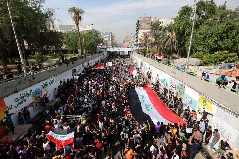 Iraqi protesters carry national flags as they protest in Baghdad, Iraq. EPA