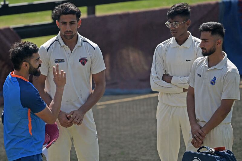 India's Virat Kohli speaks with young cricketers during a practice session. AFP