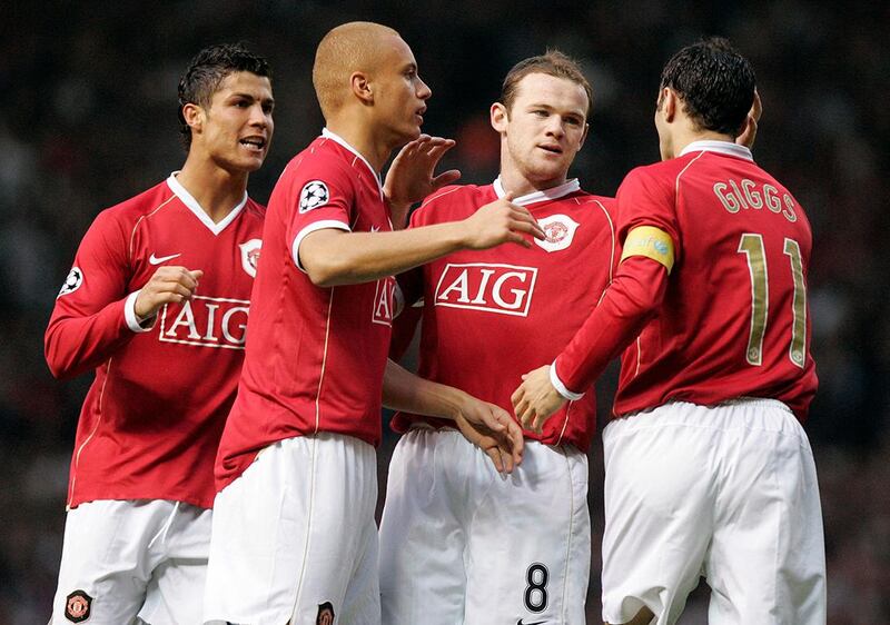 Manchester United's Portugese midfielder Cristiano Ronaldo (L) and British forward Wayne Rooney (2R) are congratulated by team mates after AC Milan conceeded a own goal during their European Champions League semi final first leg football match at Old Trafford in Manchester, north west England, 24 April 2007. AFP PHOTO/CARLO BARONCINI (Photo by CARLO BARONCINI / AFP)