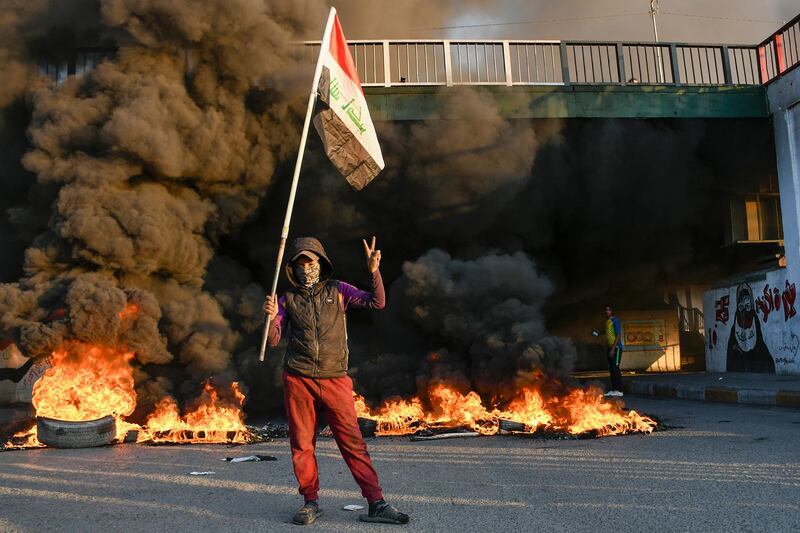 Iraqi Anti-government demonstrators block a road with debris and burning tires in the southern Iraqi city of Nasiriyah.  AFP