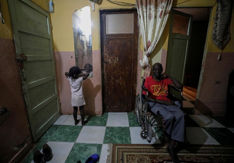 Sundanese refugee Ayat Mohamed’s sick father sits on a wheelchair at their home in Ain Shams district, amid concerns about the spread of the coronavirus disease in Cairo, Egypt. Reuters