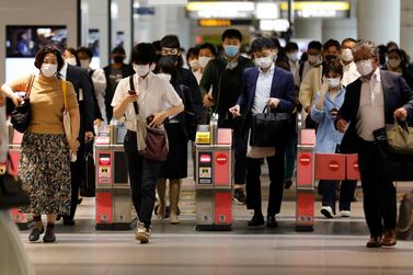 Passengers wearing protective face masks at a subway station in Tokyo. Japan is looking to roll out at a fresh $1.1tn stimulus to boost its economy. Reuters.  