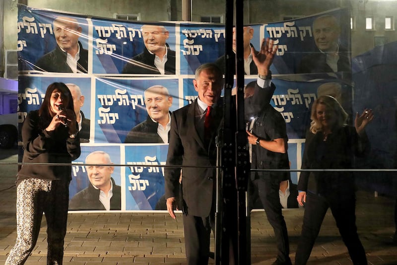 Benjamin Netanyahu addresses supporters from behind a security screen beside his wife Sara, right, and Likud member Miri Regev during a campaign rally in the northern city of Tirat Carmel. AFP