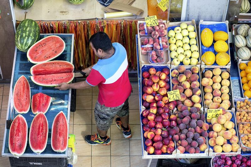 A stall holder cuts a watermelon at a fruit and vegetable stall inside an indoor market in Rome, Italy, on Thursday, Aug. 17, 2017. Italy's economic recovery extended for a tenth straight quarter, boosting optimism that growth can become sustainable this year amid a rise in industrial production. Photographer: Alessia Pierdomenico/Bloomberg