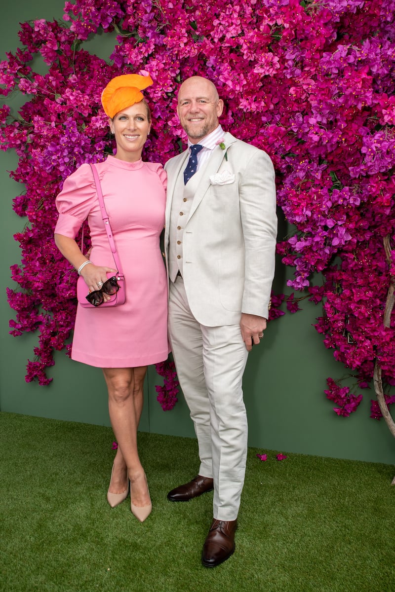 Zara Tindall, wearing a light pink silk Rebecca Vallance dress with an orange pewter headpiece by Millinery Jill and a Kate Spade bag, and Mike Tindall attend the Magic Millions Raceday at the Gold Coast Turf Club on January 11, 2020. Getty Images