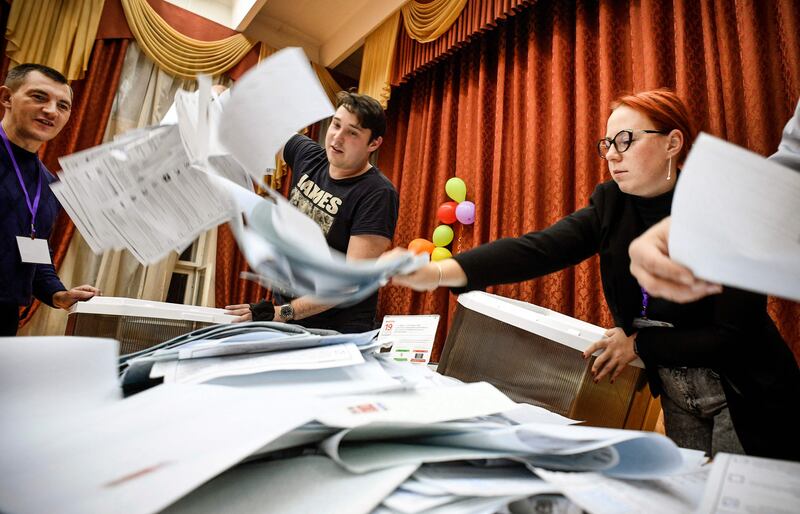 Officials empty ballot boxes at a polling station, after the last day of the Russian parliamentary election, in Moscow, on Sunday. AFP