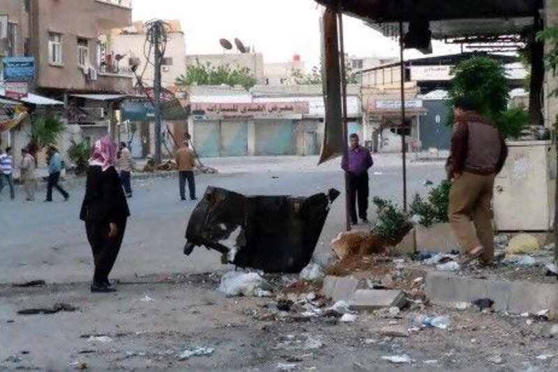 Syrians walk past debris caused by an alleged Syrian government offensive in the city of Duma yesterday.