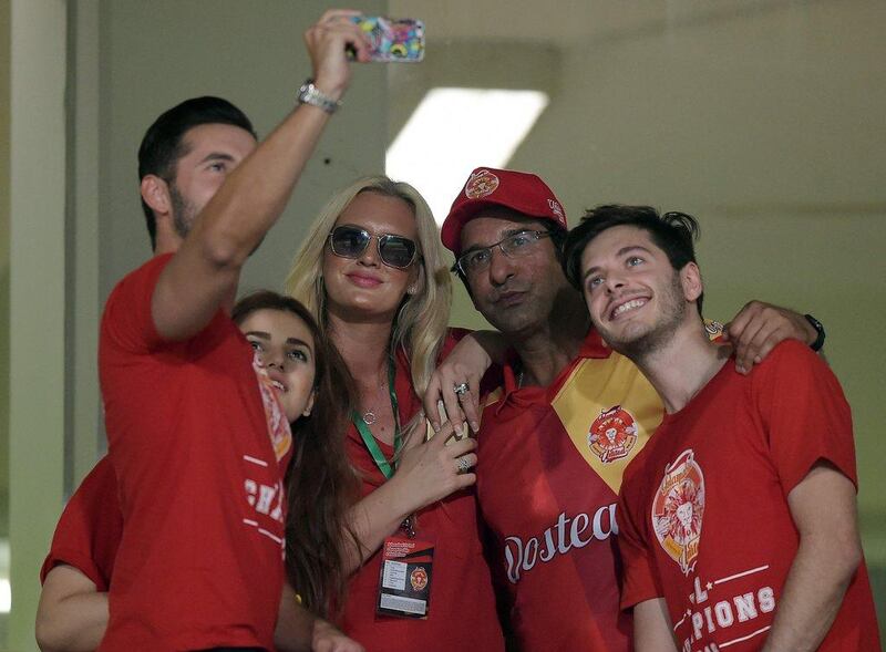 Pakistani director and bowling coach of Islamabad United Wasim Akram, secod right, and his wife Shaniera Akram, third left, take a group selfie. Aamir Qureshi / AFP