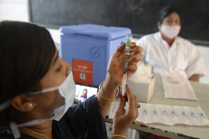 A health worker prepares to inoculate a resident during a vaccination drive for low-income citizens at a school in Hyderabad, India.