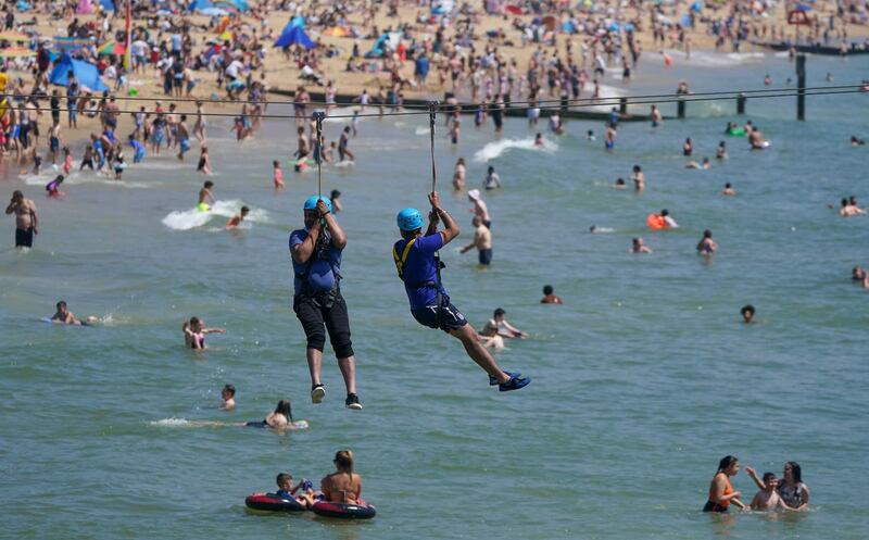 People use the zip wire across the sea from Bournemouth pier, as large numbers of people visit the coast during warm weather on Bournemouth beach. AP Photo