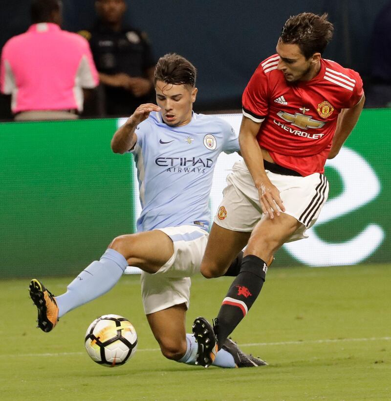 Manchester City's Brahim Diaz, left, tries to drive past Manchester United's Matteo Darmian. David J. Phillip / AP Photo