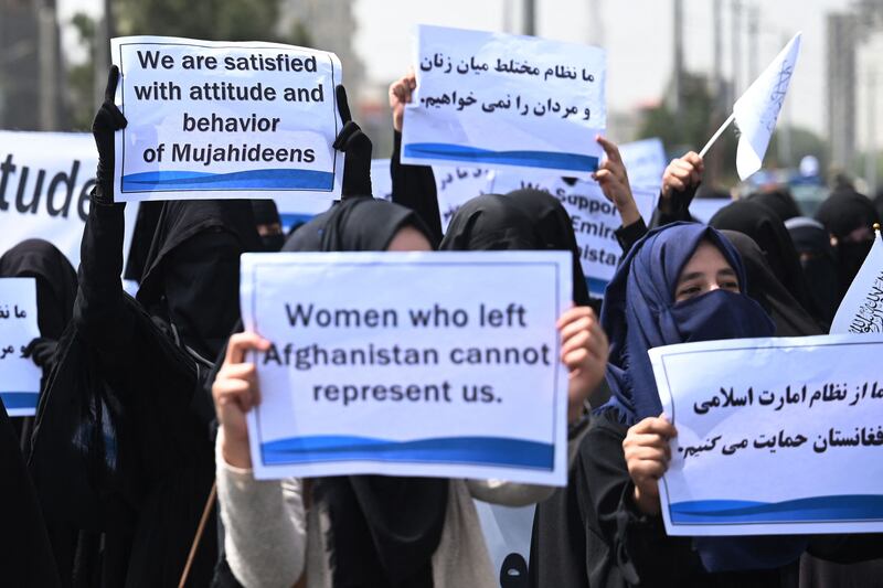 The veiled women hold banners and placards proclaiming their backing for the militant group who have taken over Afghanistan. AFP