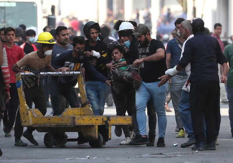 An injured protester is rushed to a hospital during clashes between Iraqi security forces and anti-government protesters in central Baghdad, Iraq, Thursday, Nov. 7, 2019. Iraqi security forces opened fire on Thursday, killing several protesters as they were trying to remove barriers blocking their march in central Baghdad, while in the south, demonstrators forced the closing of the country's main port, hours after services had resumed following days of closure, officials said. (AP Photo/Hadi Mizban)