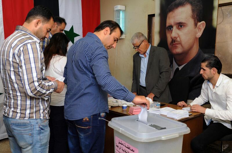 In this photo released by the Syrian official news agency SANA, Syrians cast their votes at a polling station during municipal elections, in Damascus, Syria, Sunday, Sept 16, 2018. Syria is holding its first municipal elections since 2011 amid tensions with the country's self-administered Kurdish region, which is refusing to allow polls. (SANA via AP)