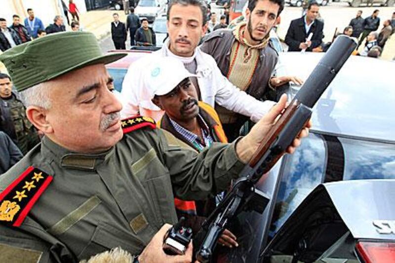 A Syrian officer shows an Arab league monitor, second left, a weapon confiscated from what officials say were gunmen during a monitor's tour in Damascus.