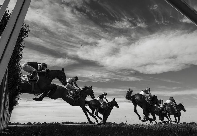 General view of riders and horses jumping the last in Race 1,  Crisp Steeplechase during The Grand National Hurdle day at Sandown in Melbourne, Australia. Vince Caligiuri/Getty Images