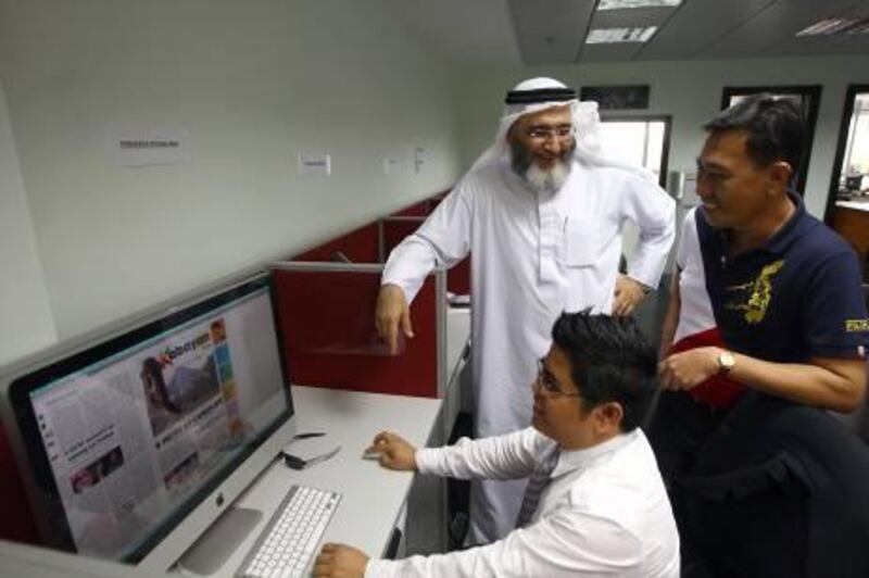 Dubai , United Arab Emirates- April 13, 2011:  ( L ) Owner and Publisher of the  New newspaper and Editor-in-Chief ,Camcer Ordonez Imam (R)  talks  to the  Designer Mohamed Manampan at their "Kabayan Weekly"  office in Dubai . ( Satish Kumar / The National )