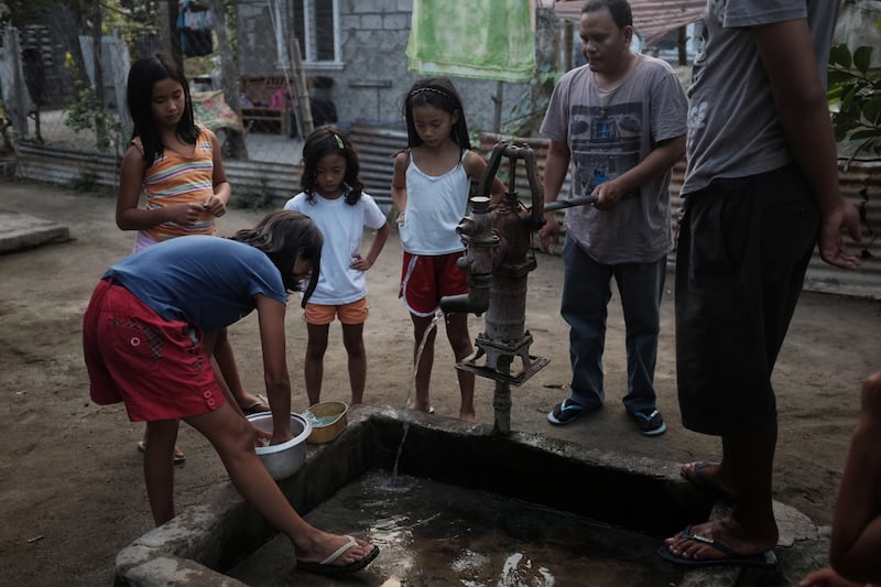 The Balwyut family use a well as they prepare for dinner with their neighbours.