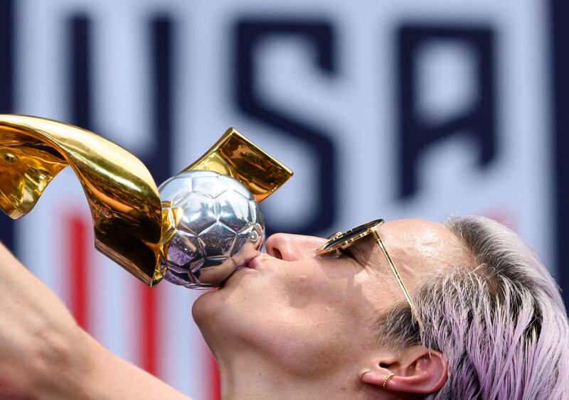USA women's soccer player Megan Rapinoe kisses the World Cup trophy the team won in 2019. AFP