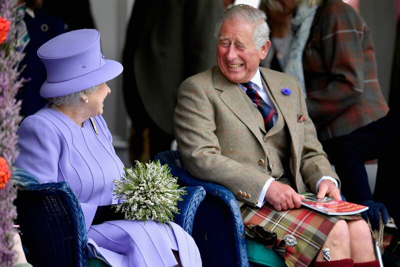 Queen Elizabeth and Prince Charles watch competitors at the Braemar Gathering in 2016.