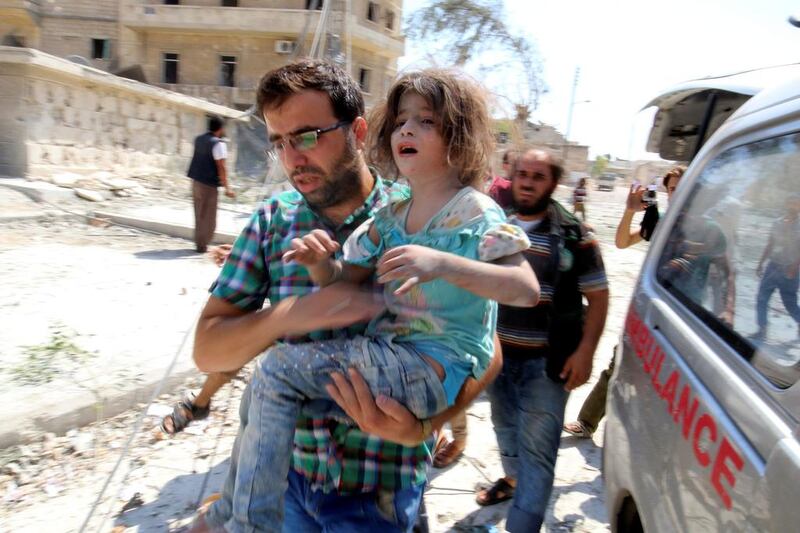 A man carries a girl that survived double airstrikes on the rebel held Bab al-Nairab neighborhood of Aleppo, Syria.  Abdalrhman Ismail / Reuters