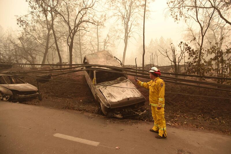 Retired CalFire firefighter Scott Wit surveys burnt out vehicles on the side of the road in Paradise. AFP