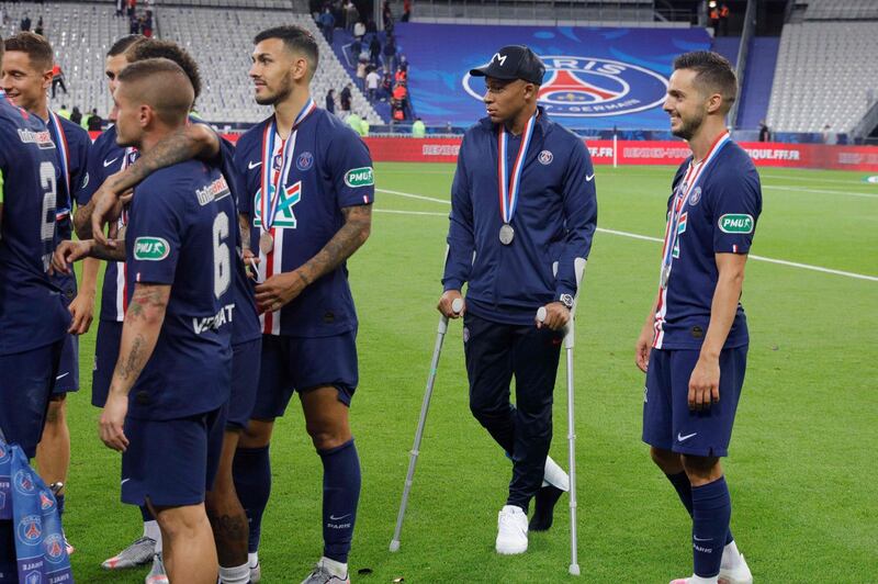 Kylian Mbappe walks with crutches. AFP