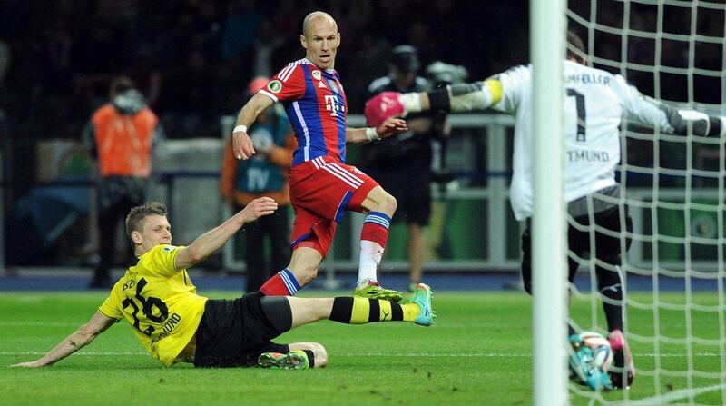 Bayern Munich's Arjen Robben, right, scores past Borussia Dortmund's Lukasz Piszczek, left, and Dortmund goalkeeper Roman Weidenfeller for Bayern's first goal in extra time during the German Cup final. Maurizio Gambarini / EPA / May 17, 2014