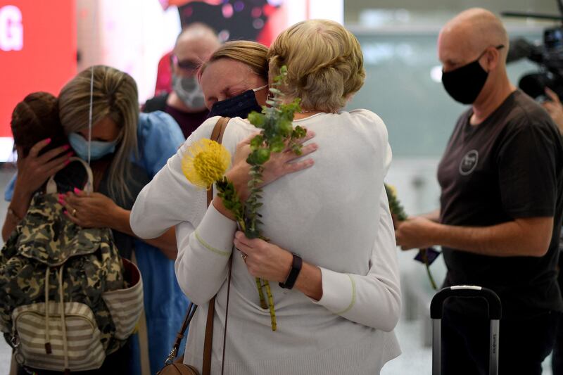 Family members celebrate upon being reunited on arrival at Sydney's international airport. AFP