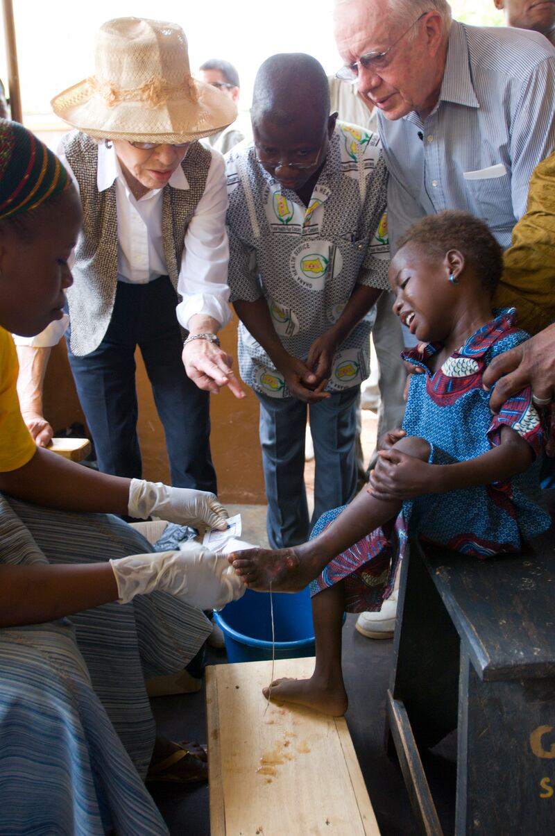 Former US president Jimmy Carter comforts a child who is being treated for Guinea worm disease. A non-profit he founded, The Carter Centre, has been on a mission to wipe out the disease.