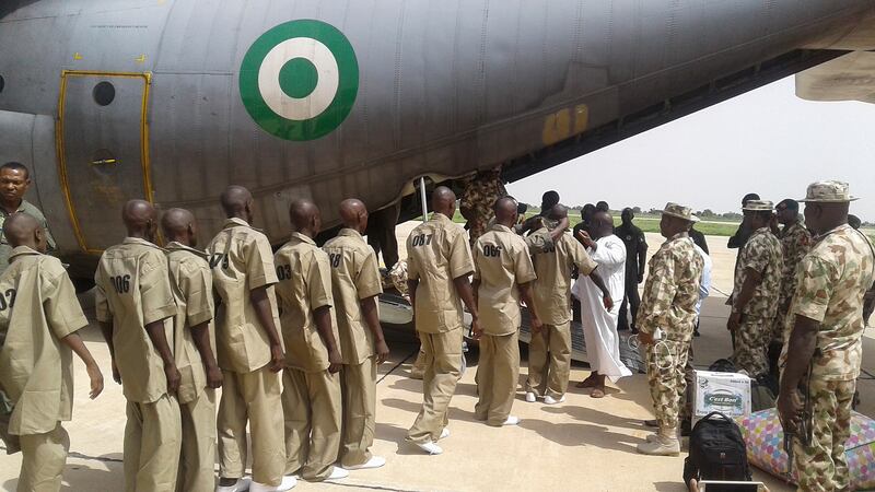 Surrendered Boko Haram fighters file on to a Nigerian military aircraft to be taken to a rehabilitation centre in Gombe, north-east Nigeria, in 2017. EPA