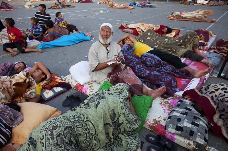 An elderly displaced Palestinian man looks up towards the sky after an explosion was heard nearby as many slept in the courtyard of the UN Jabalya Boys School on July 21, 2014. Heidi Levine for The National