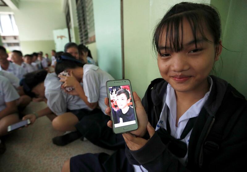 epa06879499 A Thai student shows a photograph of her classmates, Duangpetch Promthep, who has trapped in Tham Luang cave, on her mobile phone after a teacher announced he had been rescued, at Maesaiprasitsart School in Mae Sai district, Chiang Rai, Thailand, 11 July 2018. According to reports, all 13 members of a soccer team, including their assistant coach, have been rescued and taken to a hospital after being trapped in Tham Luang cave since 23 June.  EPA/RUNGROJ YONGRIT