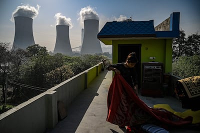 A girl folds a blanket at her house rooftop near the Thermal Power Corporation plant in Dadri, India, in April. AFP
