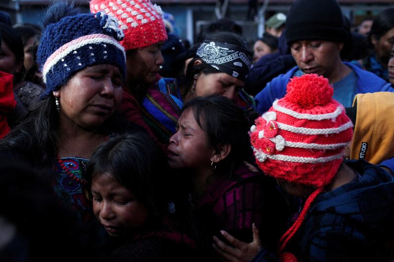 Relatives of migrant Pascual Melvin Guachiac, 13, who died last month when he suffocated while being smuggled in a trailer in San Antonio, Texas, mourn during a memorial at a school in the small village of Tzucubal, Guatemala. Reuters