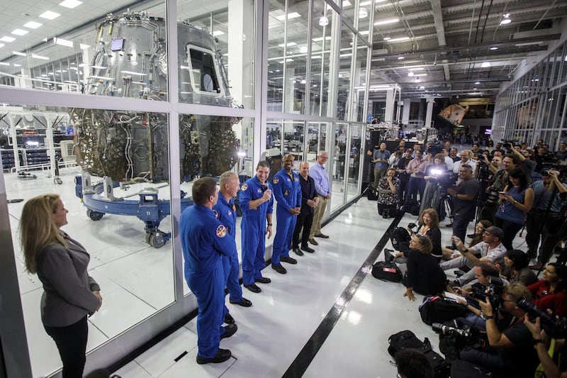 Gwynne Shotwell, president and chief operating officer of SpaceX, and NASA astronauts Bob Behnken, Doug Hurley, Mike Hopkins, and Victor Glover, stand in front of the Crew Dragon spacecraft clean room. Bloomberg