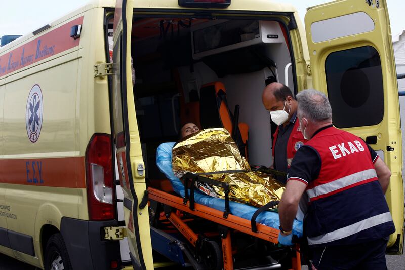 Paramedics of the Greek National Emergency Ambulance Service transfer a boat disaster survivor to their ambulance in Kalamata. EPA