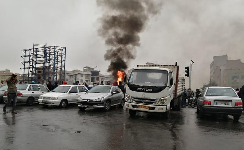 Iranian protesters gather around a fire during a demonstration against an increase in petrol prices in Tehran. AFP